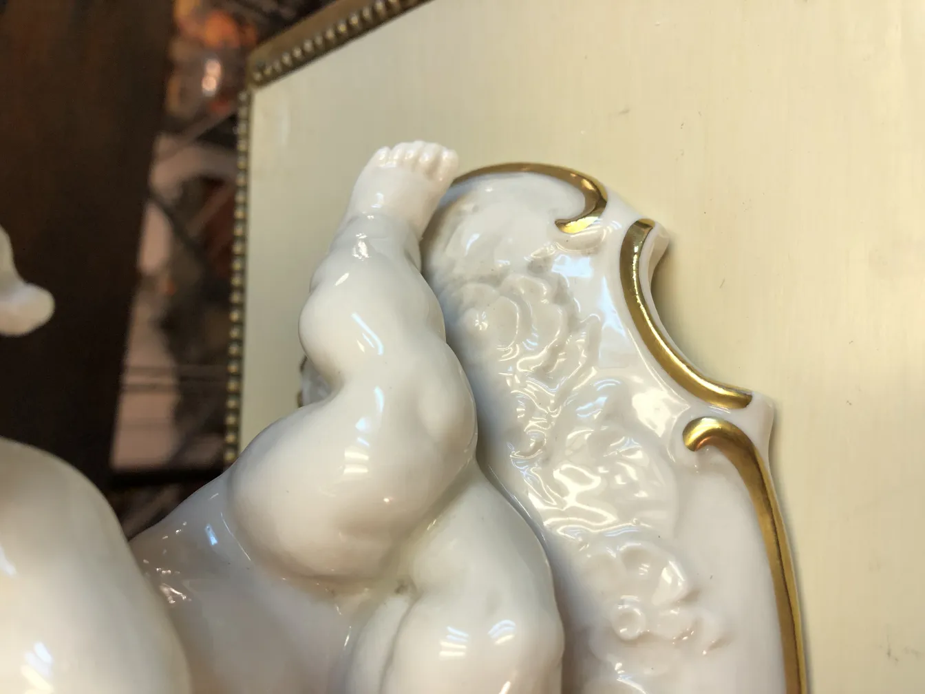 Antique ceramic sculpture featuring decorative golden details.