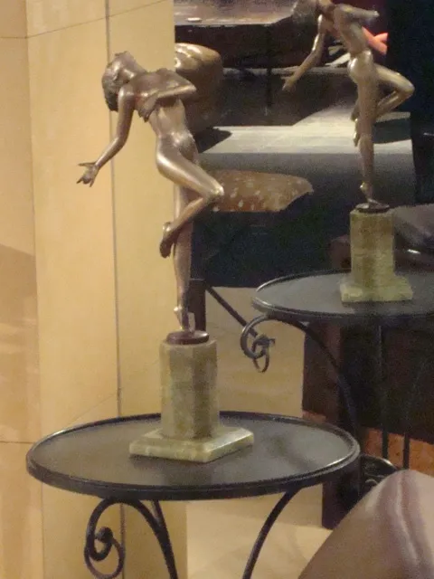 sculpture ancienne de femme en mouvement sur une base