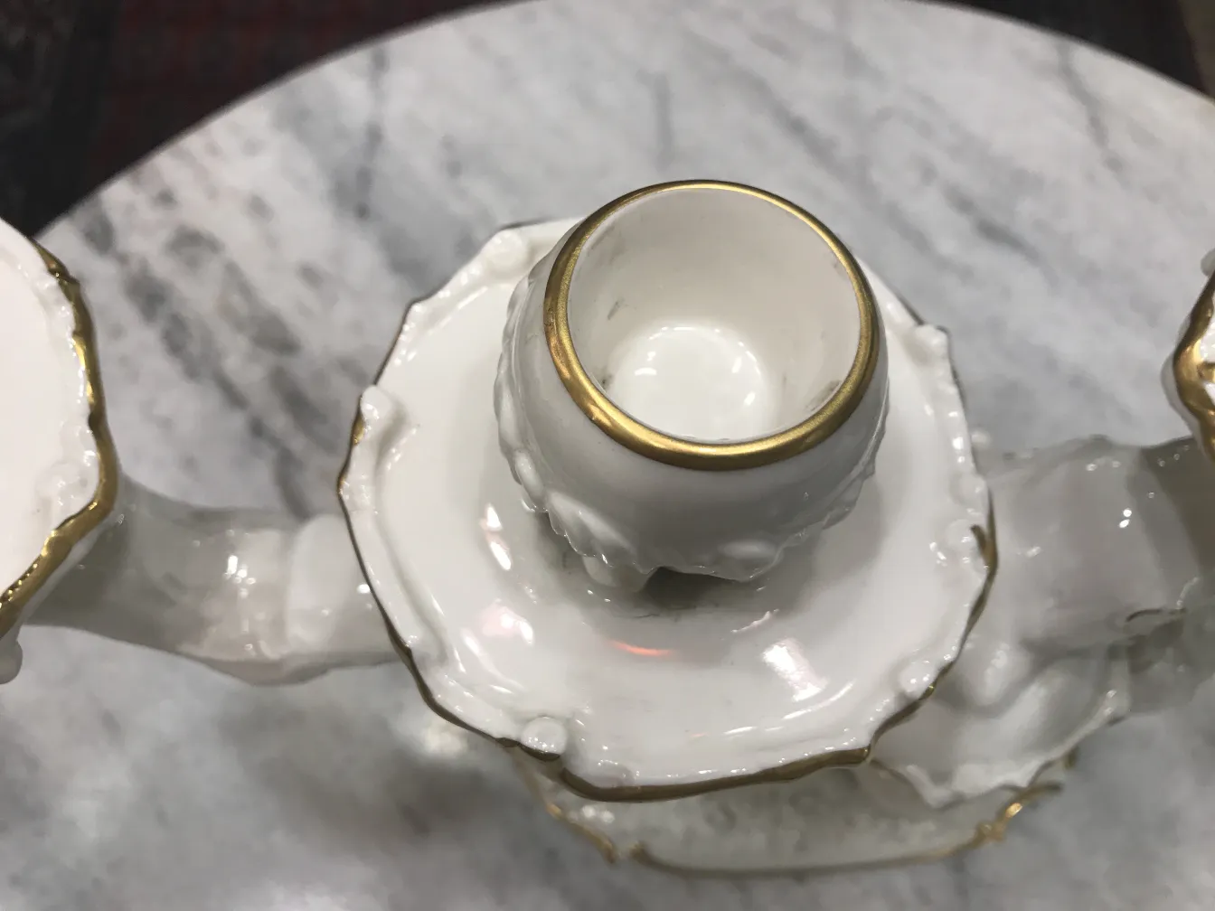 Candelabro antigo de cerâmica com detalhes dourados.