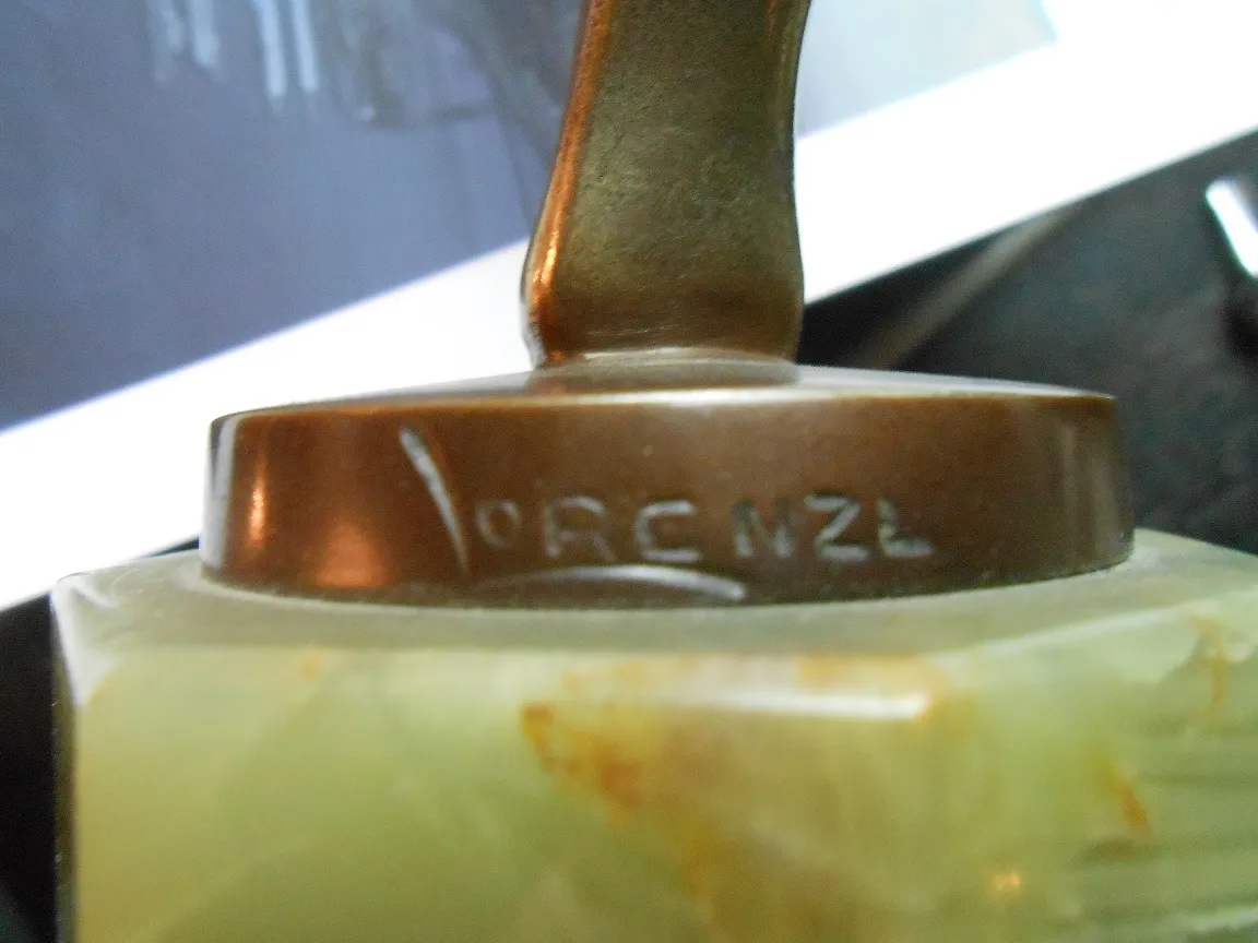 antique sculpture with decorative base and visible signature