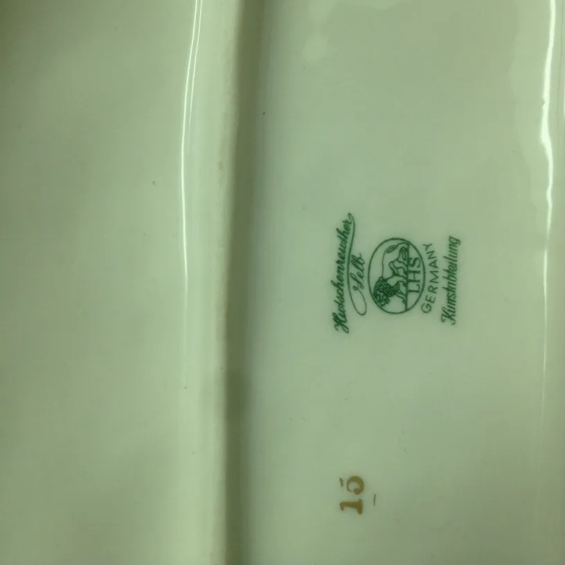 detalle de ceramica antigua con marca verde y dorada