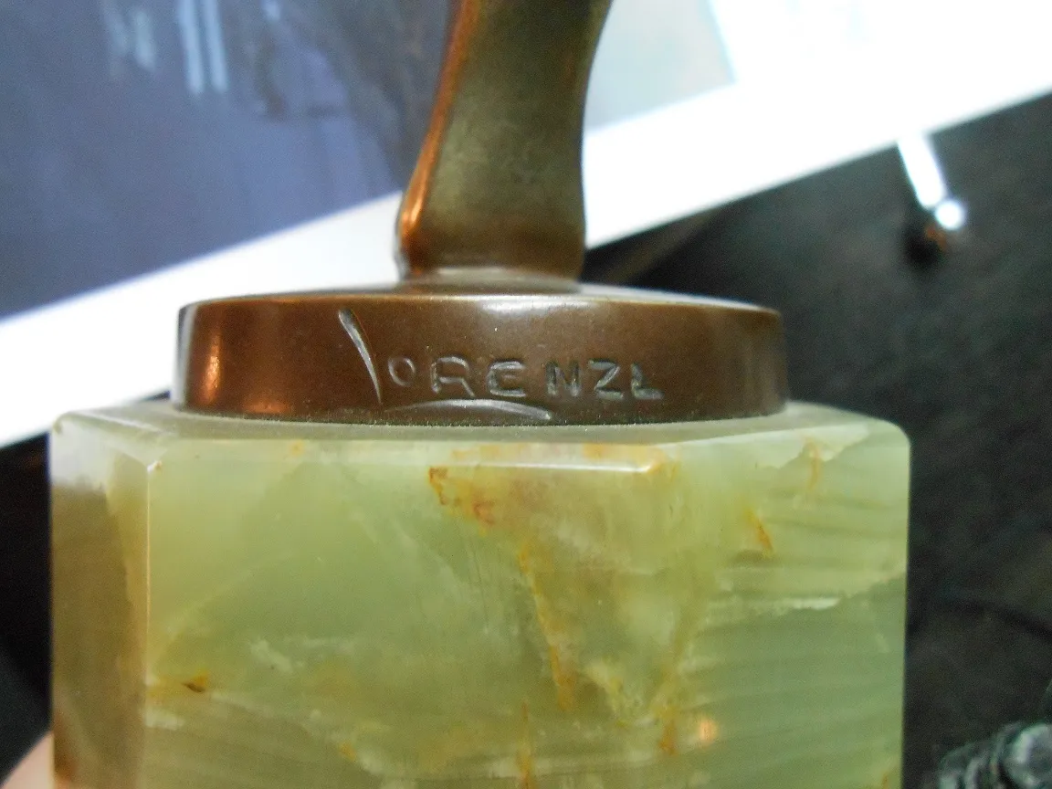 Escultura antiga com base decorativa e detalhe artístico