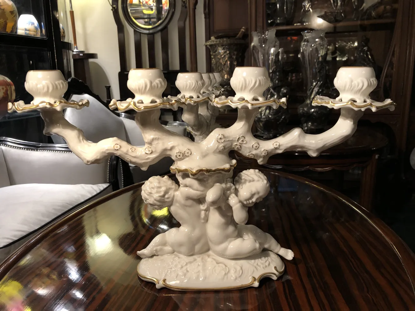 Candelabro antigo de cerâmica com esculturas decorativas.