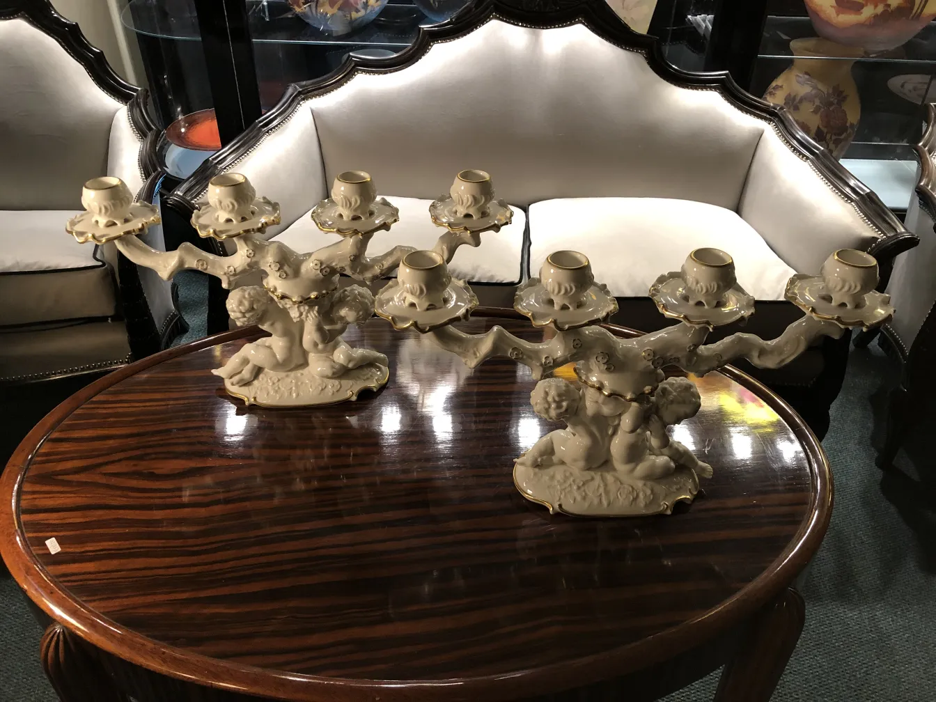 金色のアクセントが施された二つの陶器製のアンティークキャンドルホルダー、エレガントなデザイン。