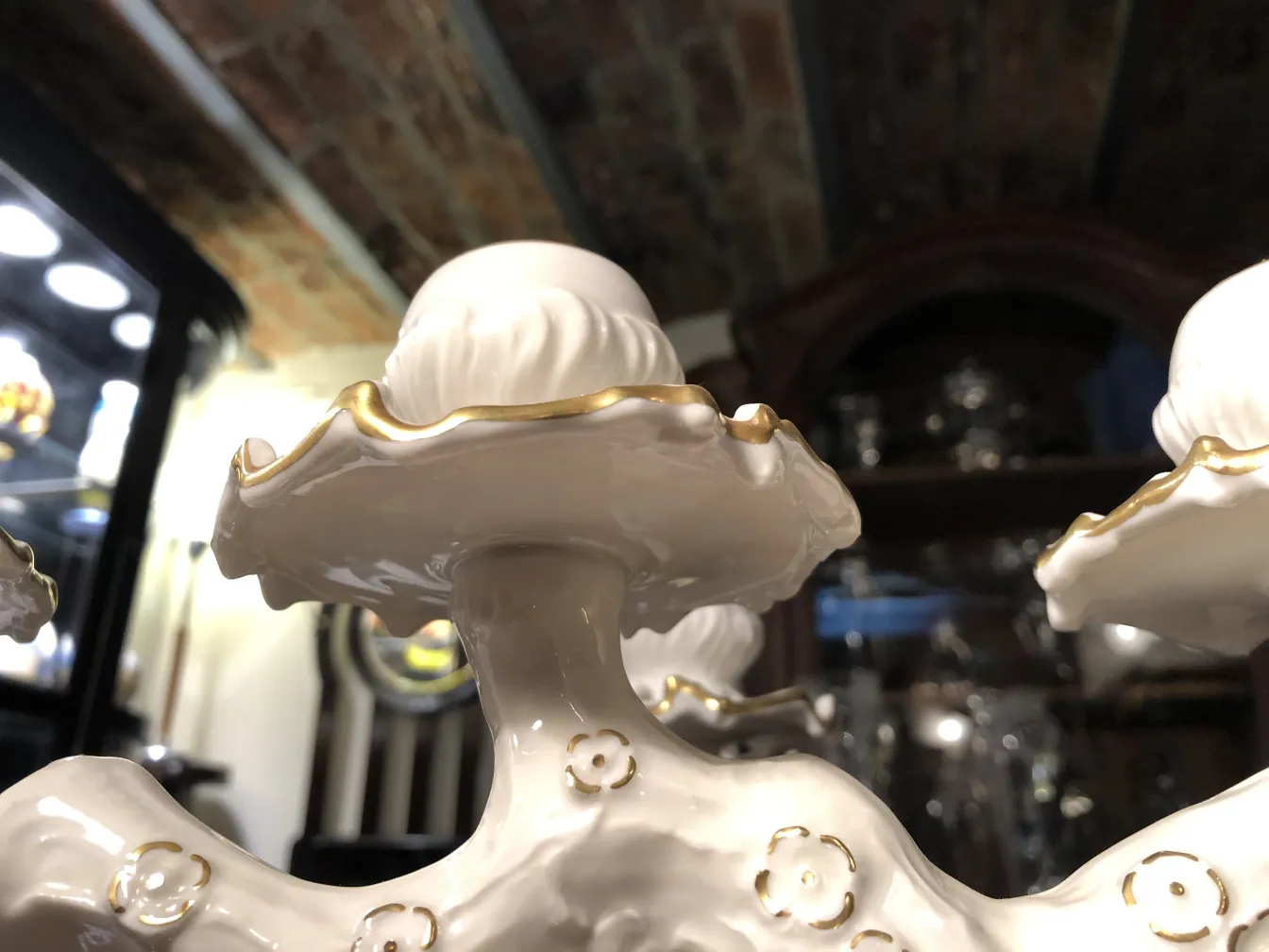 Detalles de cerámica antigua blanca decorada con dorados, en un ambiente elegante.