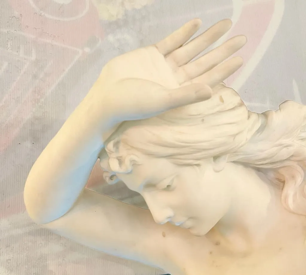 detalhe de uma escultura antiga representando uma figura feminina