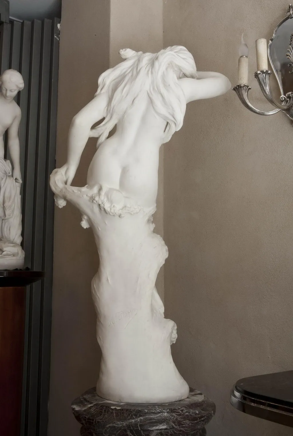 alte Skulptur mit weiblicher Figur in Pose.