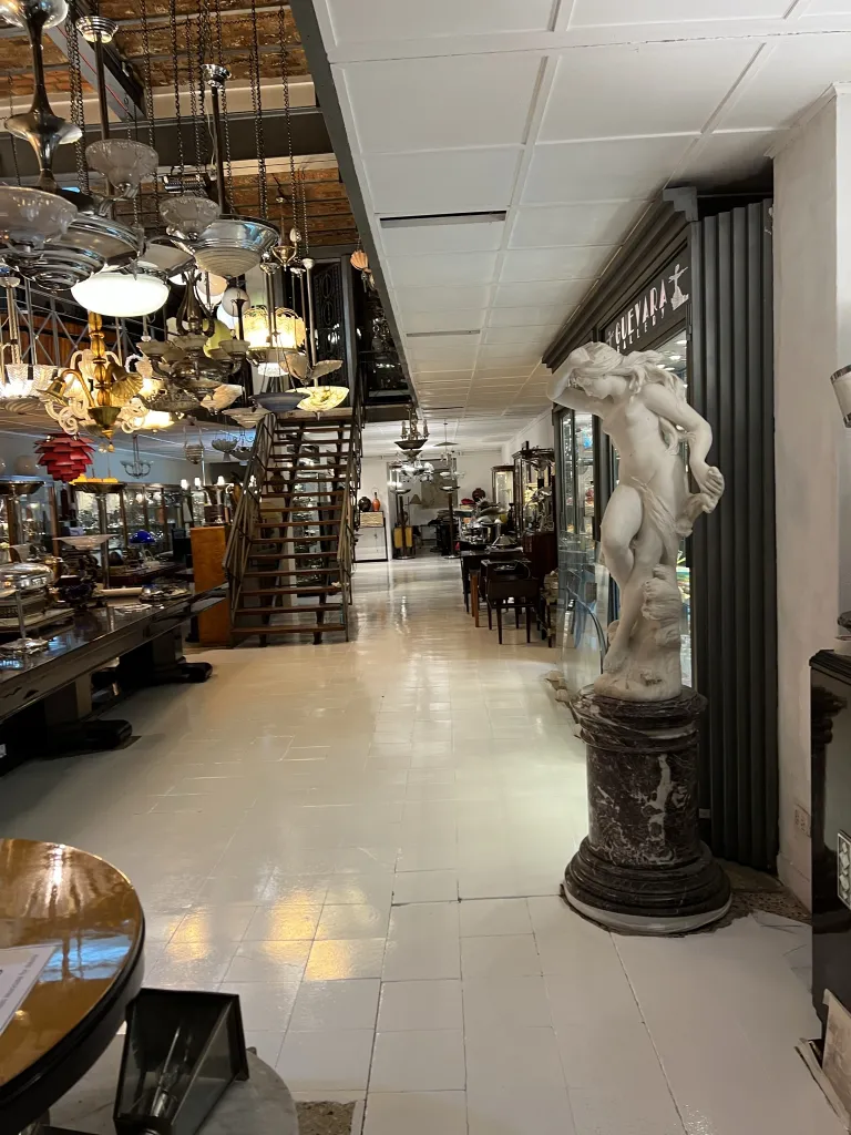 scultura antica su piedistallo con oggetti decorativi