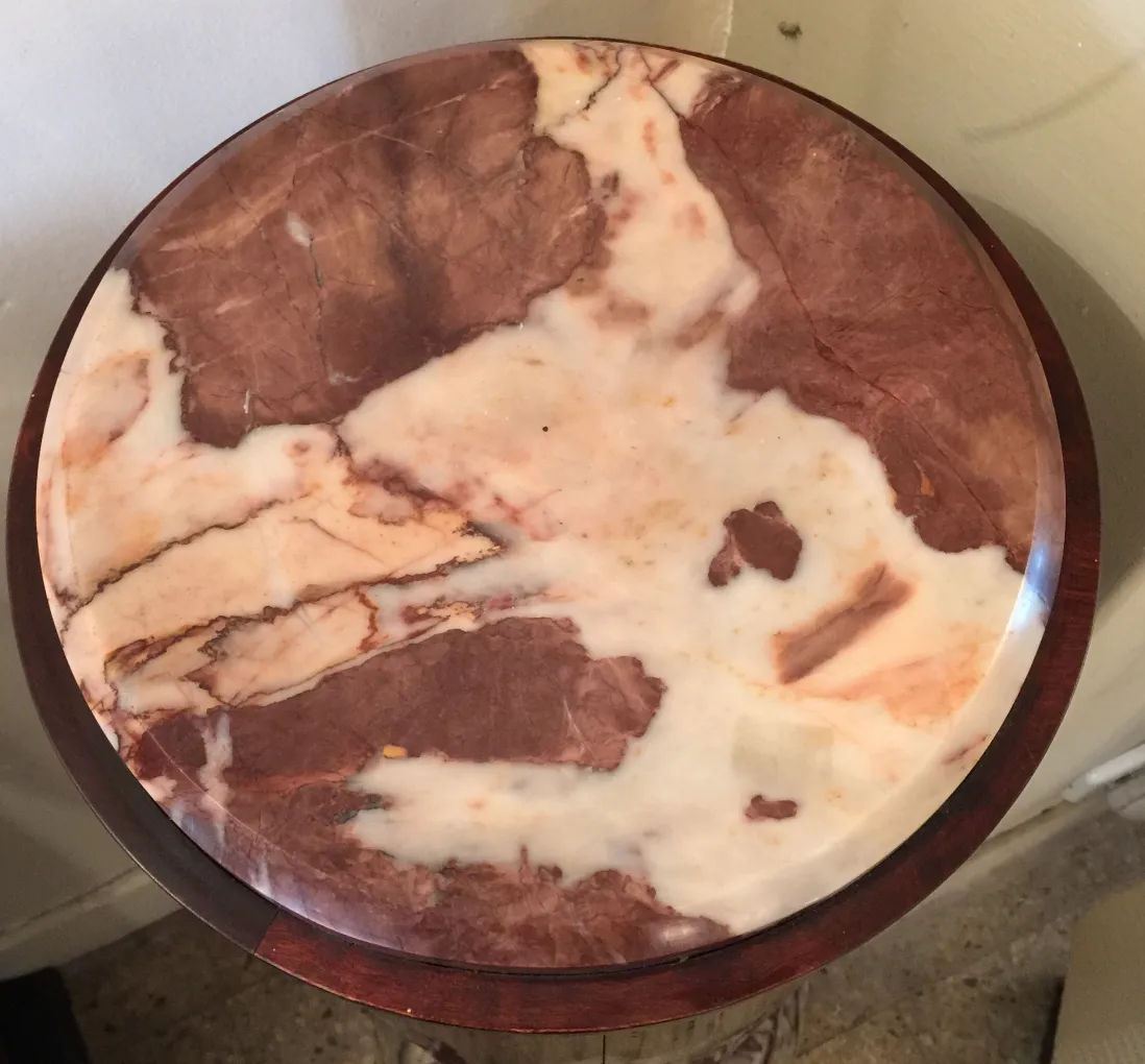 Visão superior de uma coluna antiga com superfície decorativa em tons de marrom e bege.