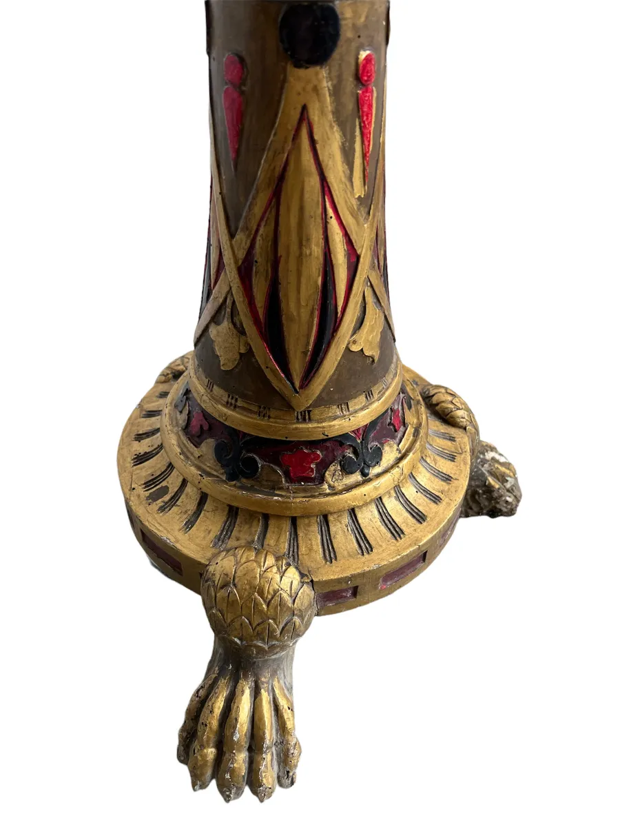 Scultura antica dorata con dettagli decorativi alla base