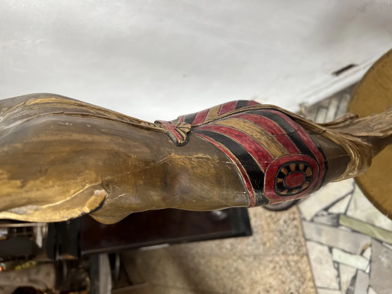 antique sculpture with decorative details in red and gold, set in a classic environment