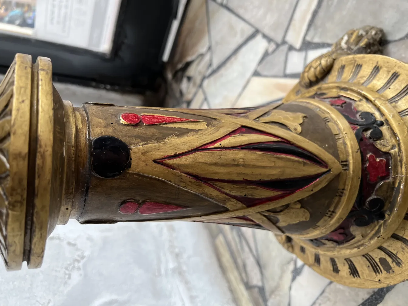 Scultura antica con dettagli decorativi in oro e rosso