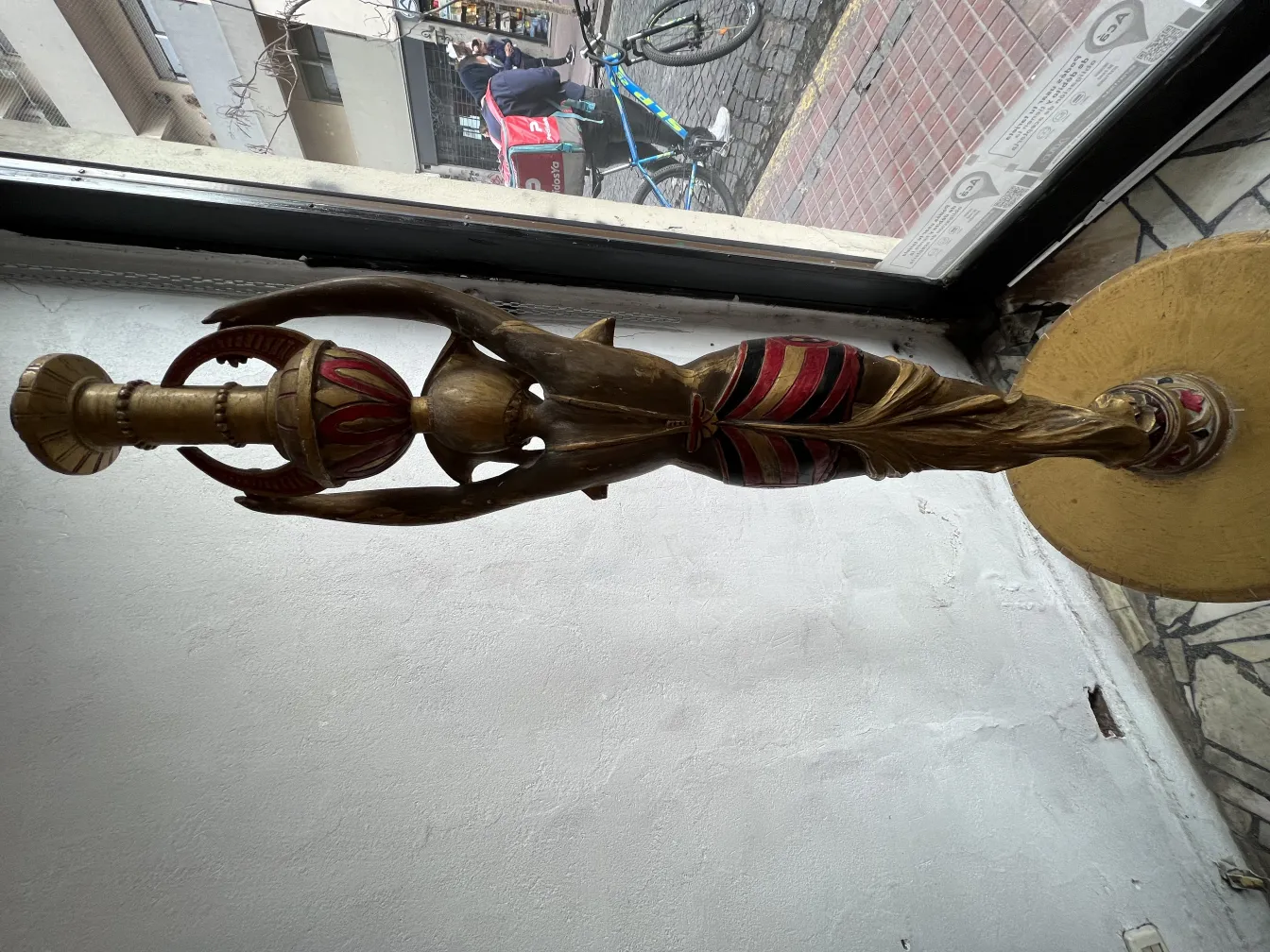 Antike Skulptur mit goldenen und roten Details, elegant.