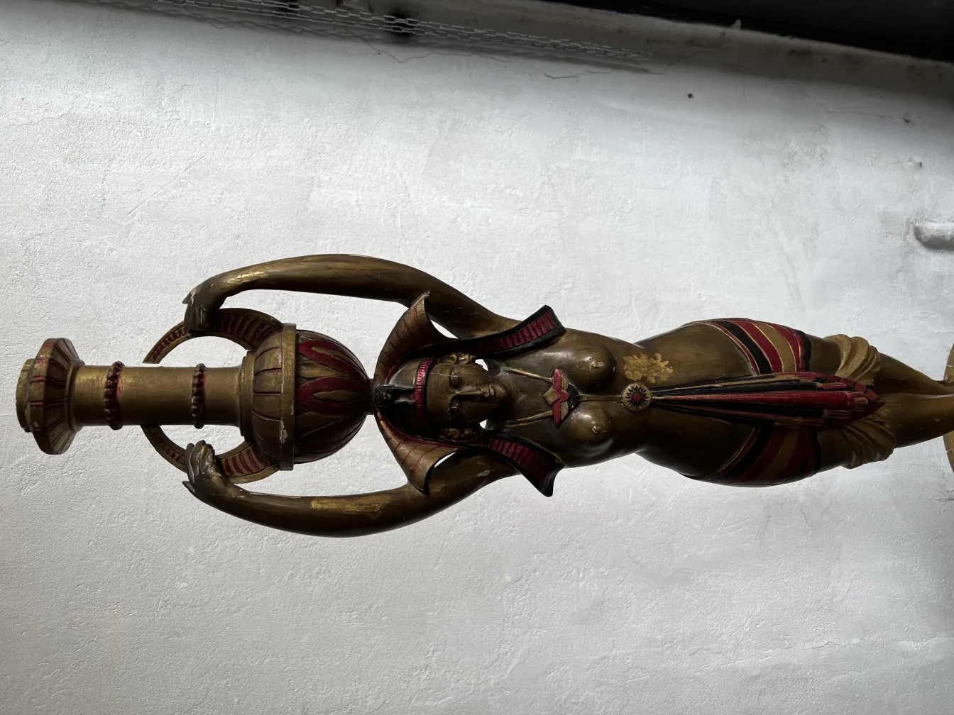 Sculpture ancienne d'une femme tenant un objet décoratif