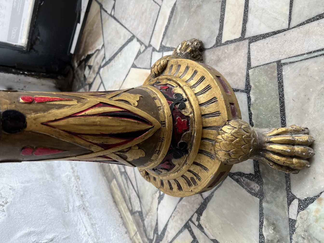 Antike Skulptur mit geschnitzten ornamentalen Details an der Basis.