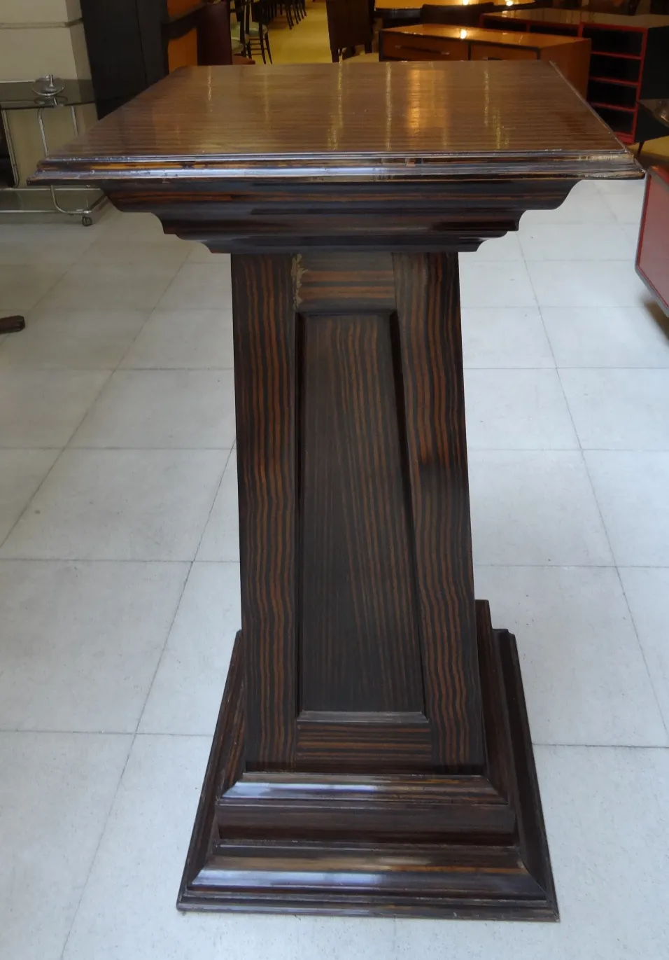 antique column with detail on top, background with furniture