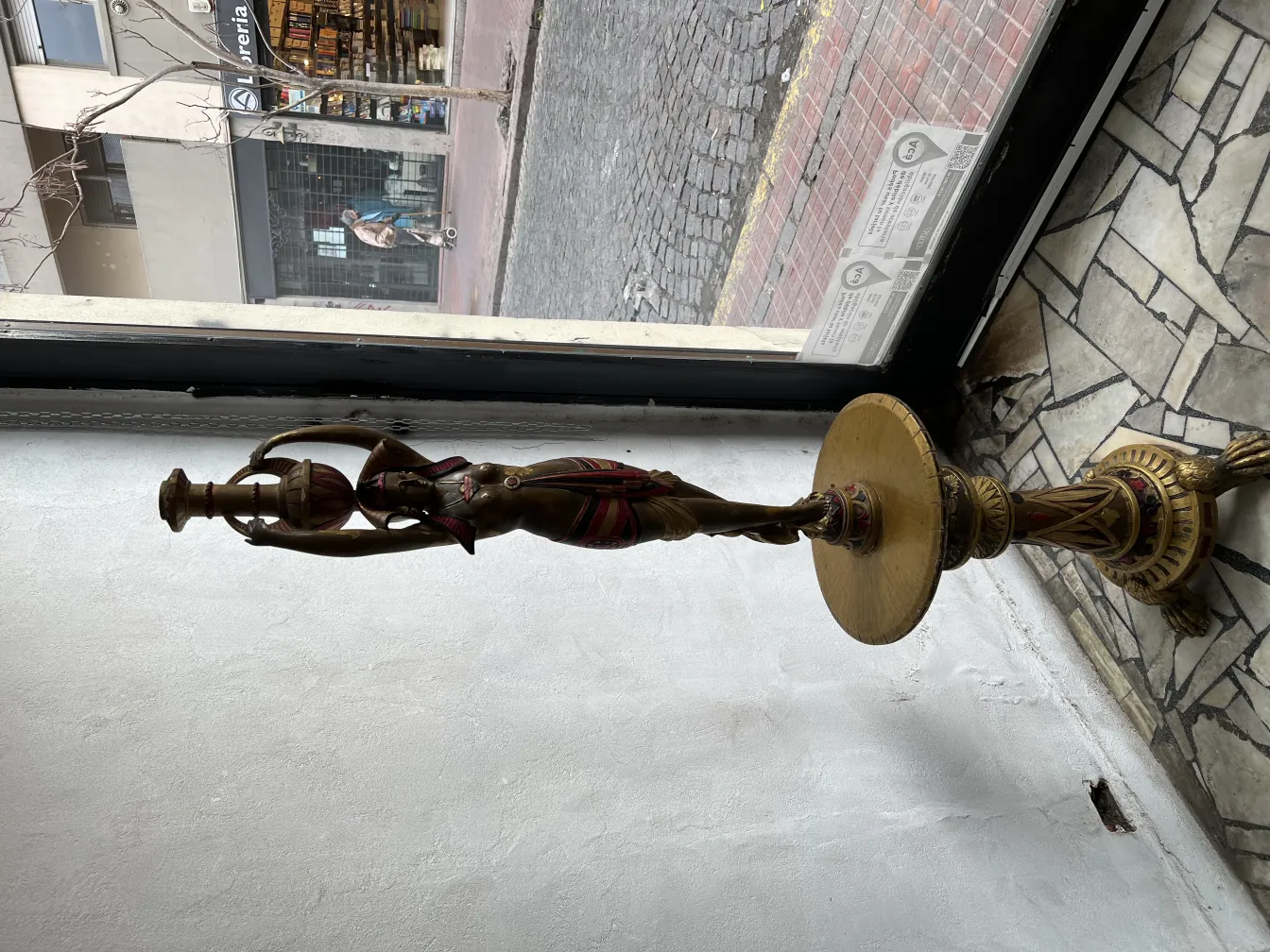 Sculpture ancienne d'une femme tenant une lampe dans un cadre élégant.