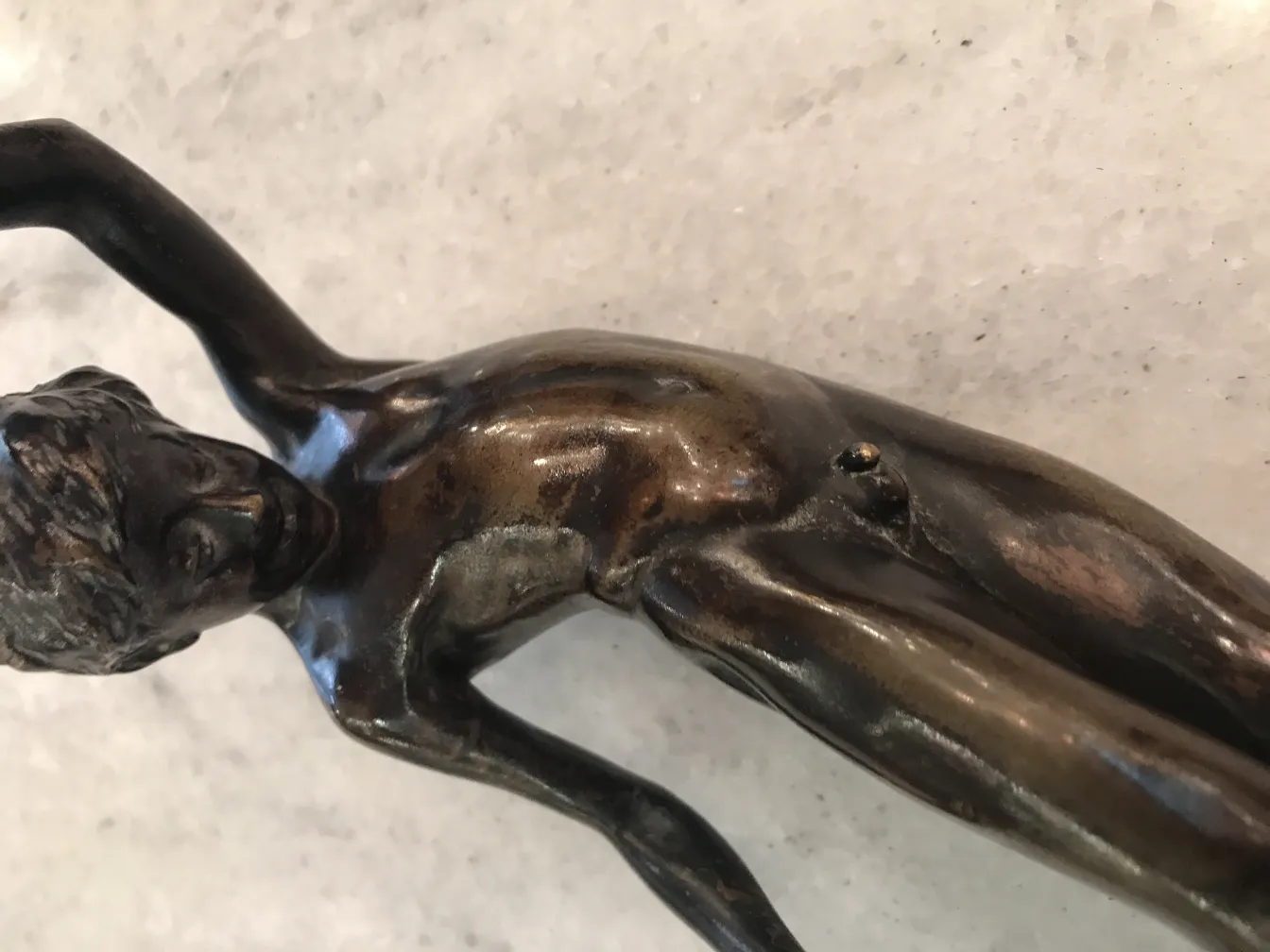 Sculpture ancienne d'une figure humaine avec des détails complexes, expressive et élégante.