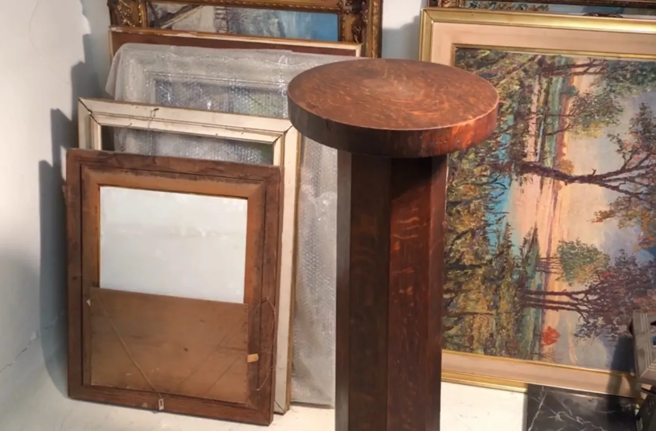 Columna antigua de madera, ideal para decoración. Fondo con cuadros y espejos.