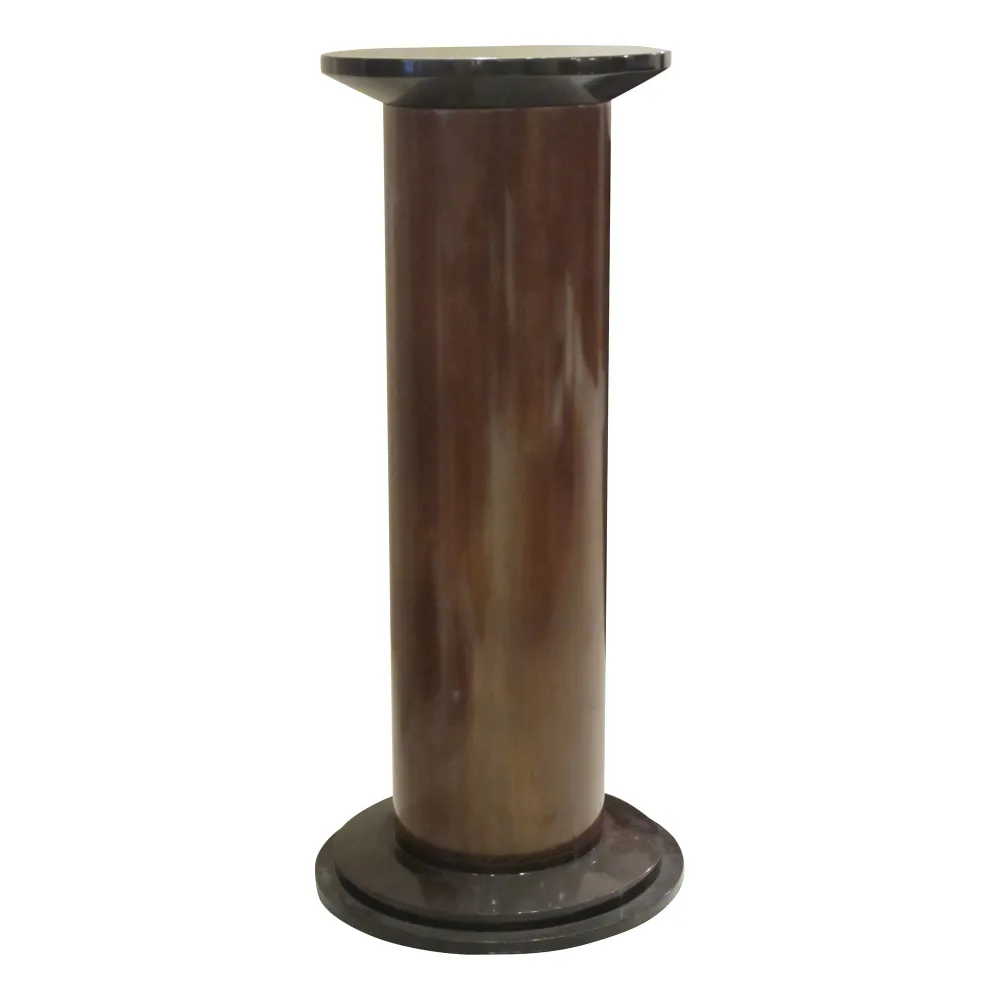 Antique decorative column with a round base and flat top in an elegant setting.