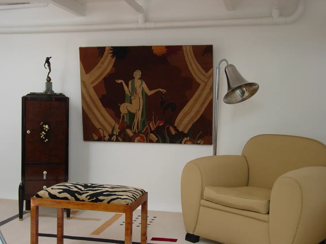 escultura antigua en un ambiente moderno con sillón y lámpara