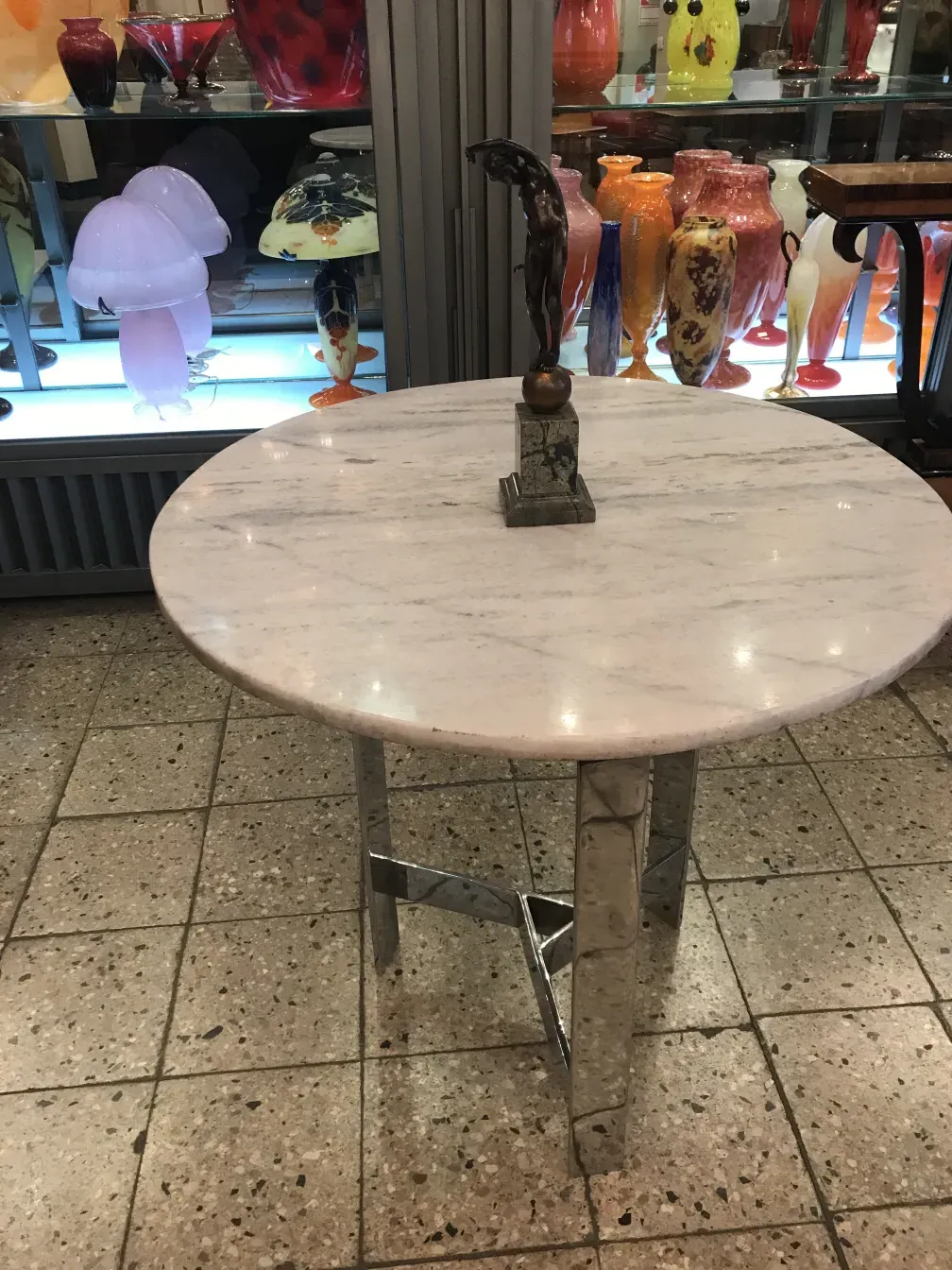scultura antica su tavolo con espositori in vetro e vasi
