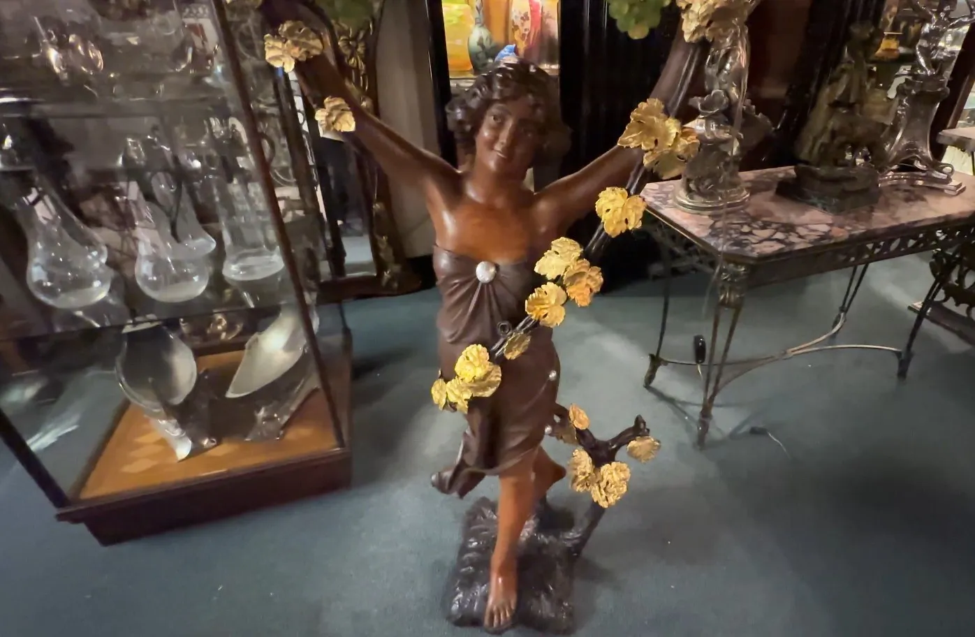 scultura antica di figura femminile decorata con fiori dorati