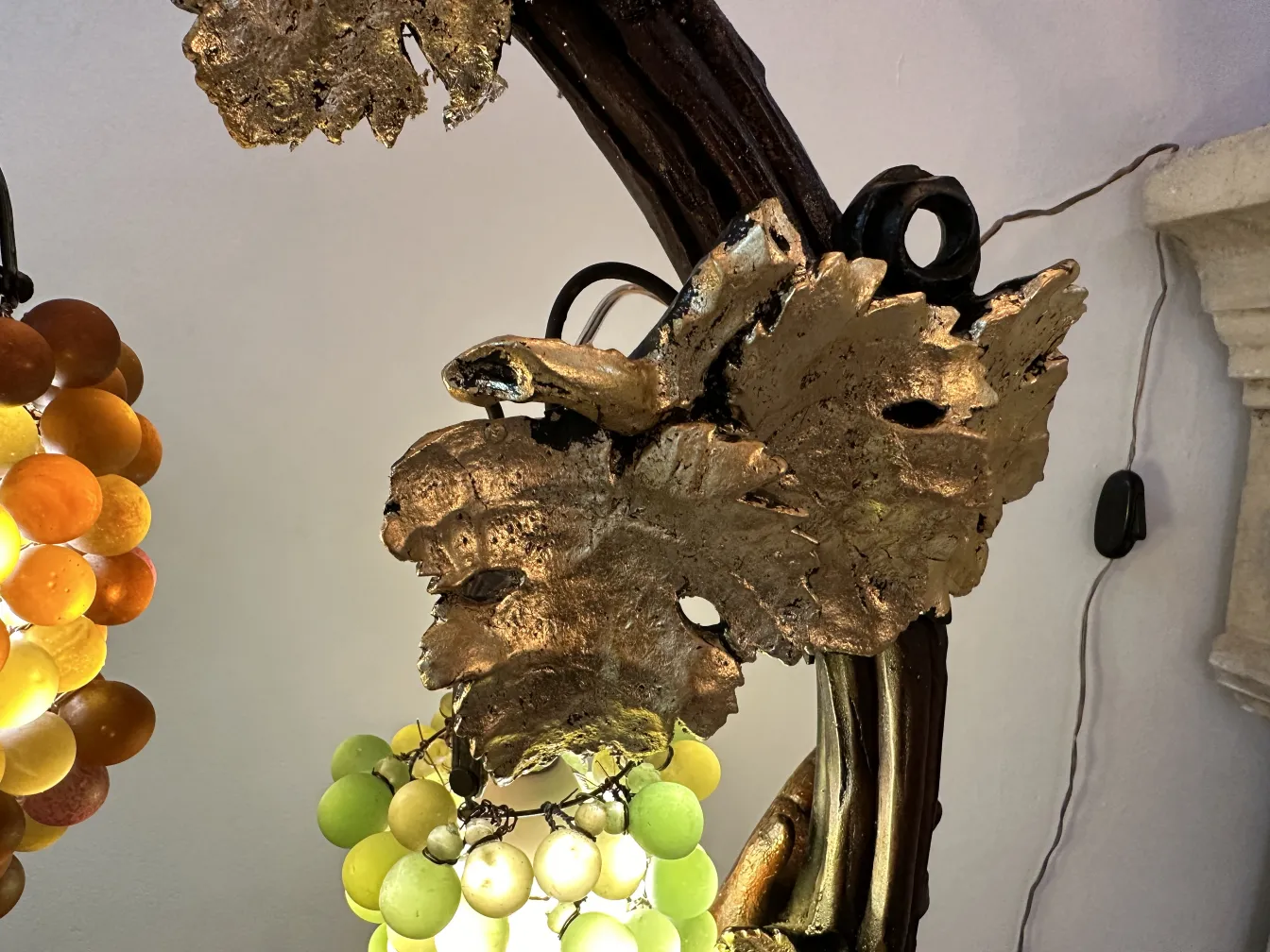Antique sculpture featuring leaves and bunches of grapes, decorative piece.