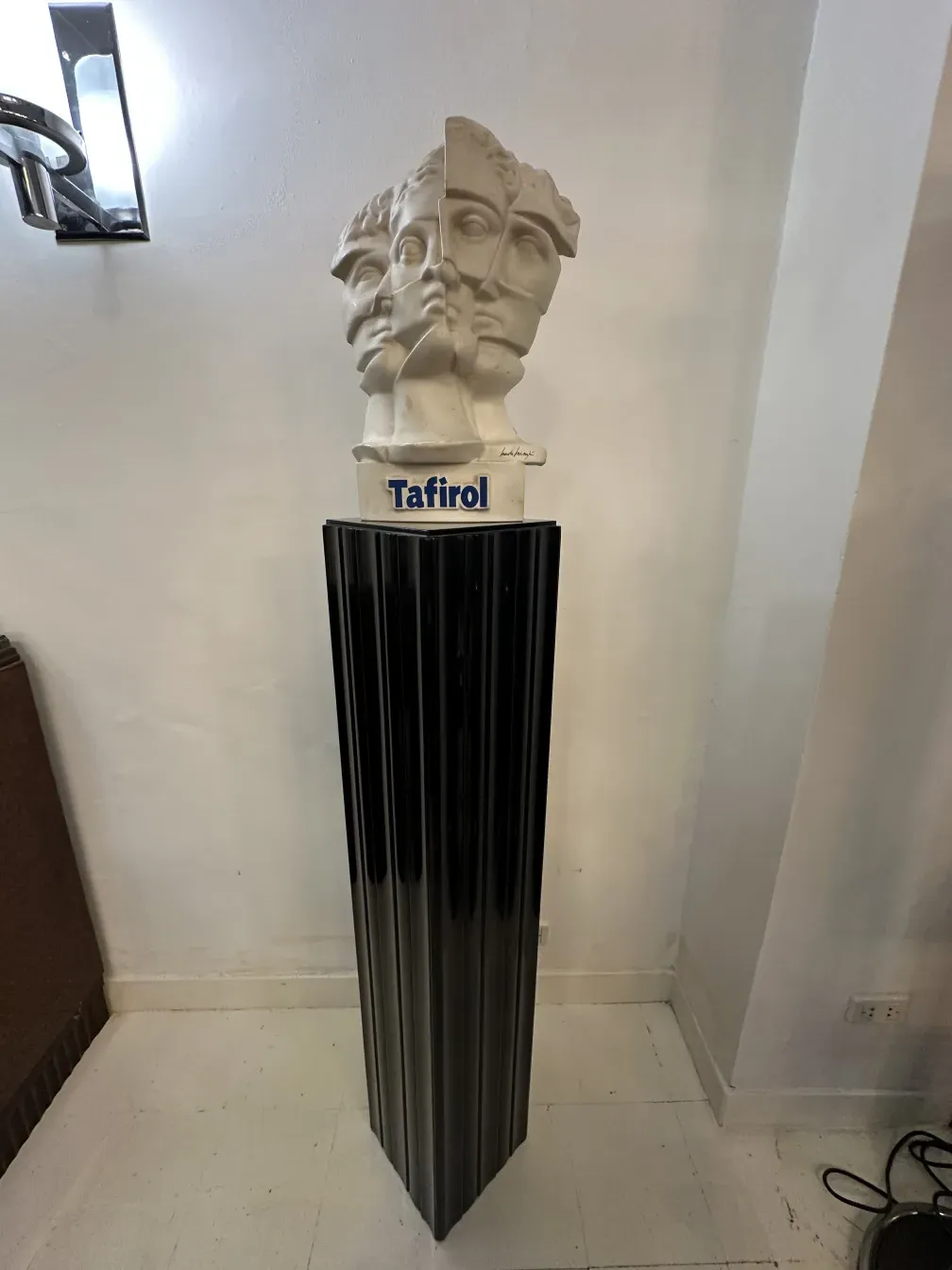 Colonna antica con scultura in cima, ambiente elegante.