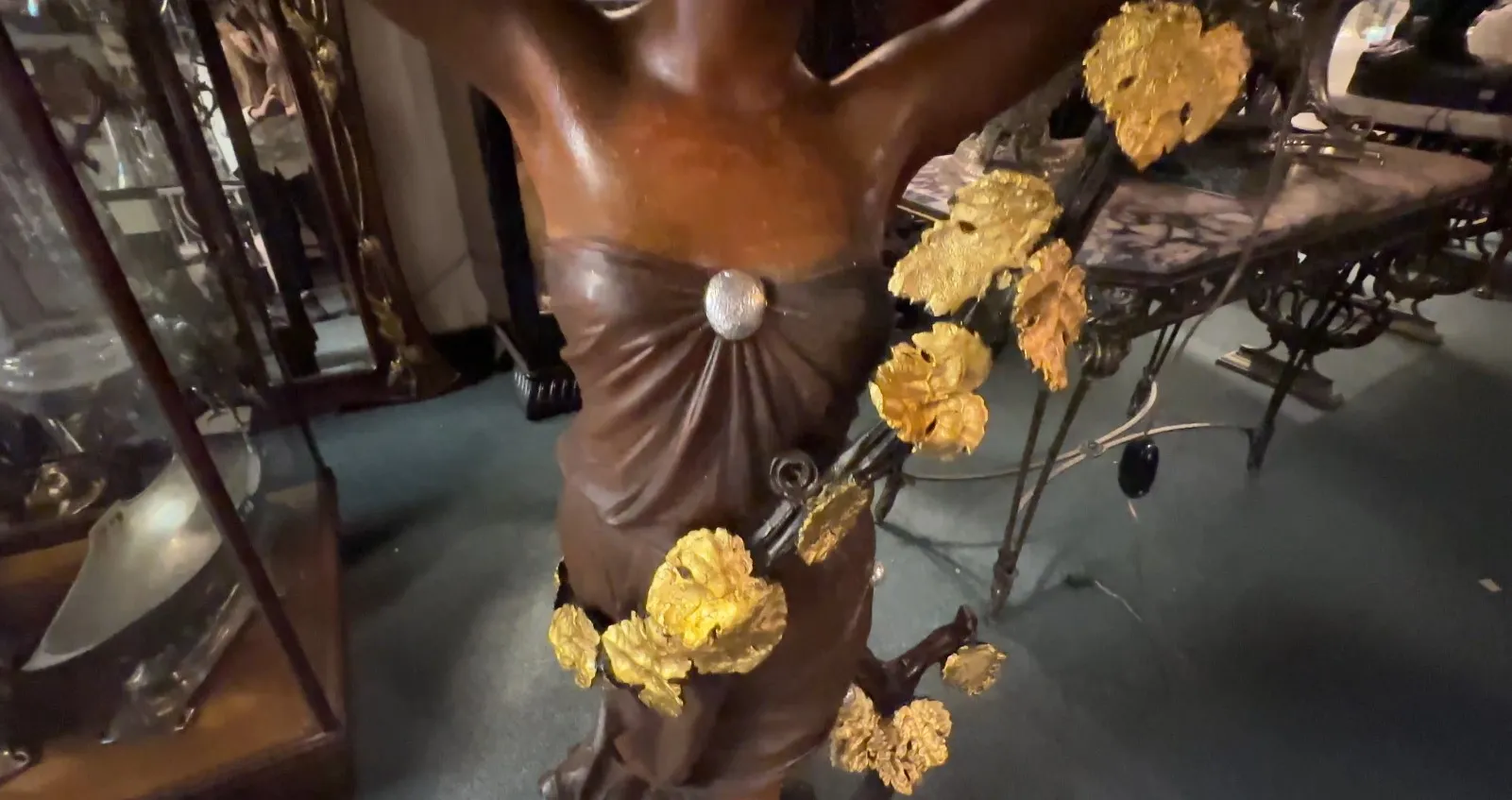 Antike Skulptur einer Frau mit goldenen Blumen in einer eleganten Umgebung