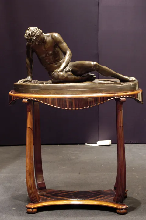 antique sculpture of a male figure reclining on elegant table