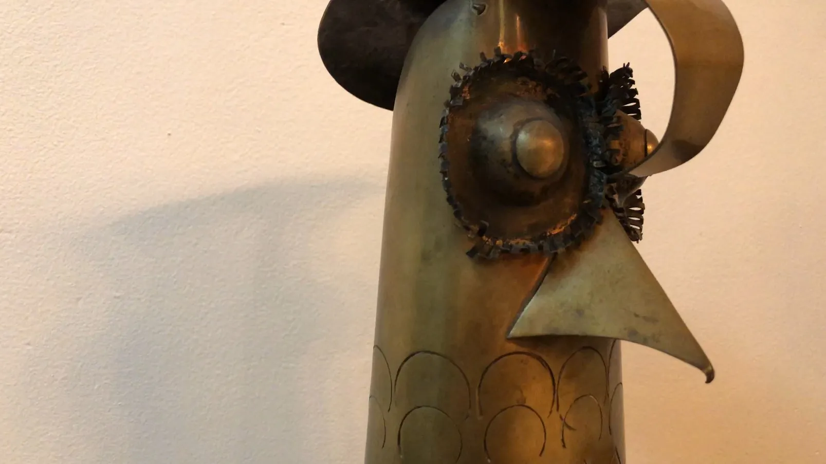 escultura antigua con forma de cabeza, detalles decorativos en metal