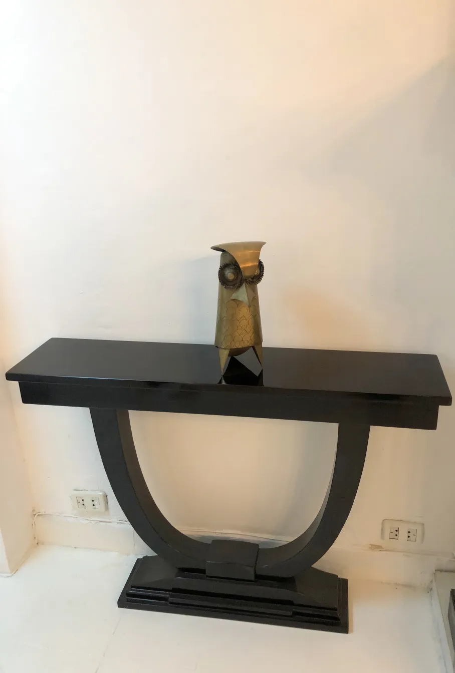 escultura antigua de búho decorativa sobre mesa negra