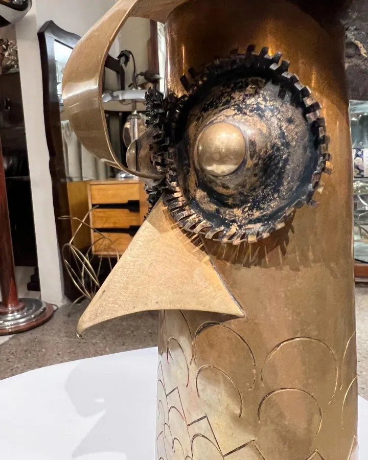 Antike Vogelskulptur mit metallischen Details und Gitter, klassisches Setting.