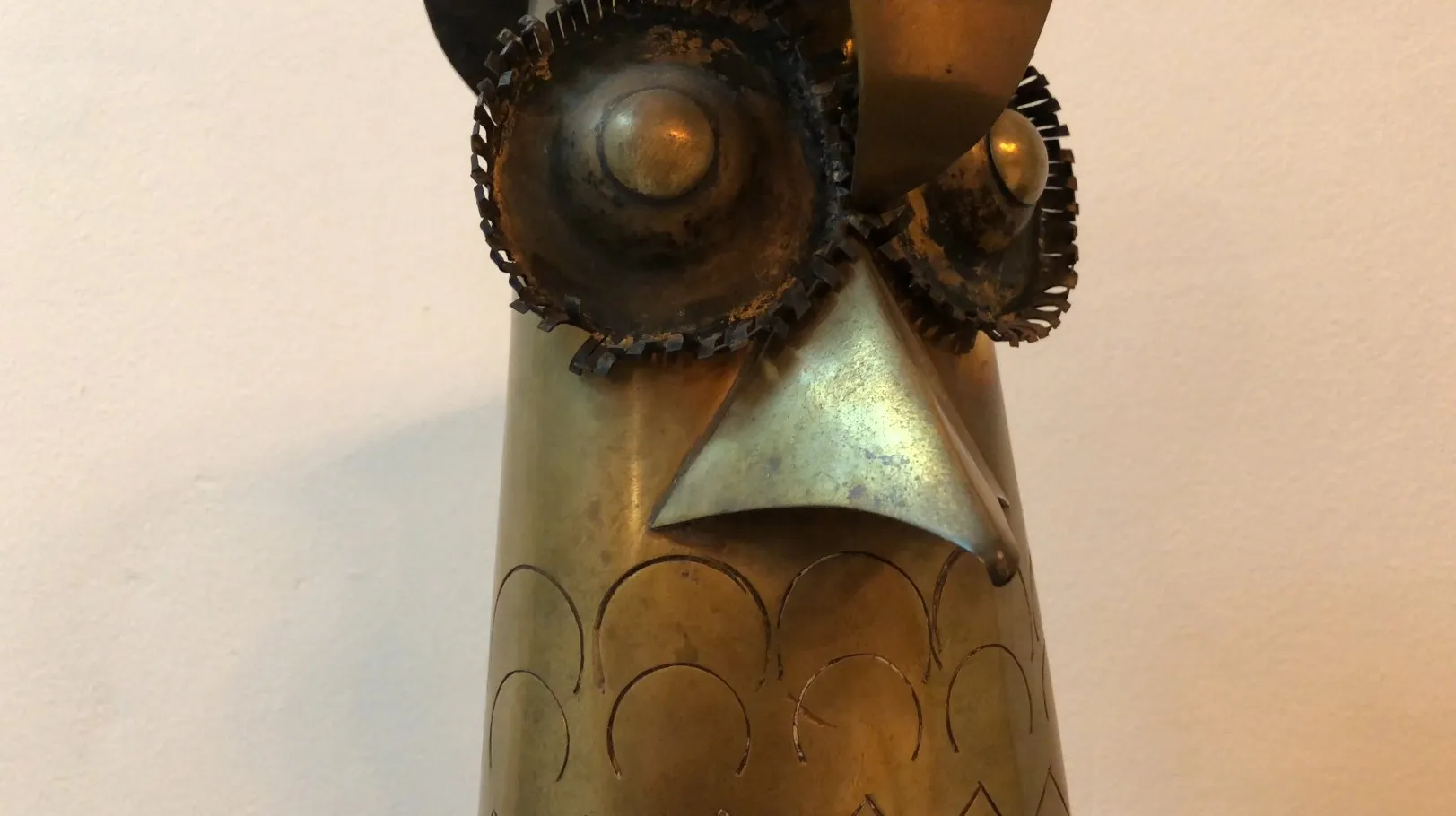 escultura antigua de un búho con detalles metálicos distintivos