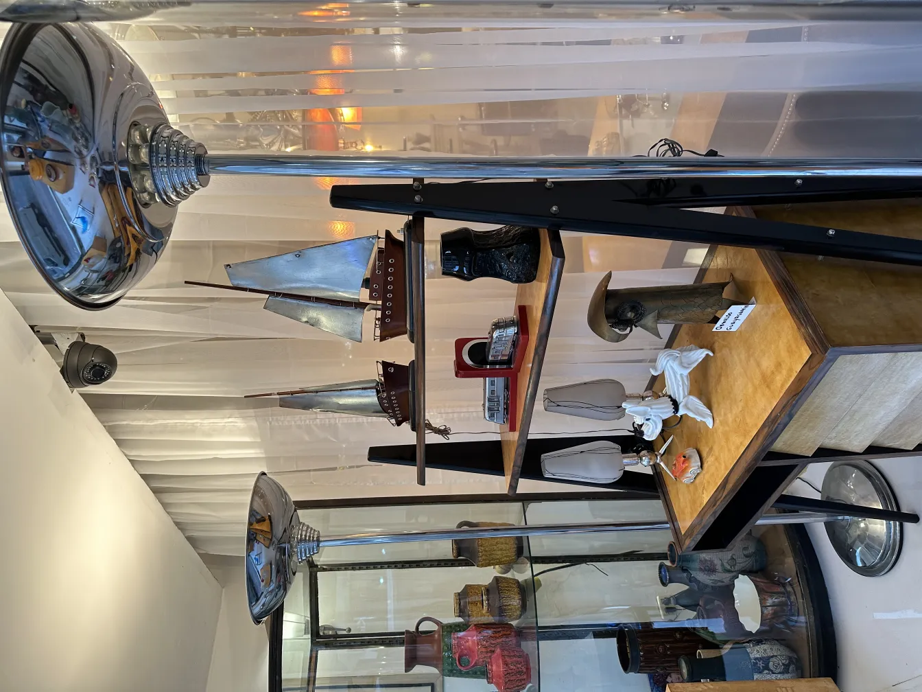 escultura antigua decorativa en exhibición con lámparas y otros objetos