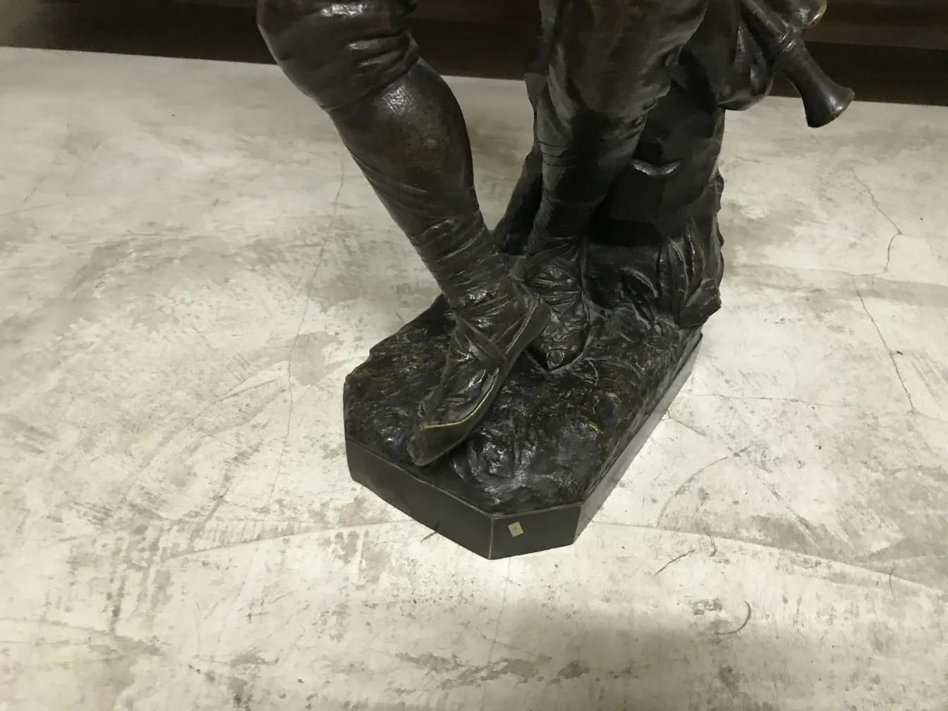 Scultura antica con dettagli decorativi fini alla base.