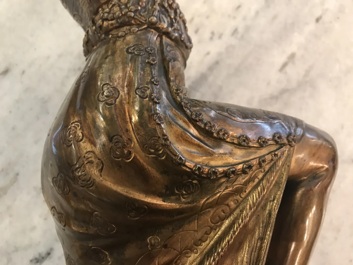 escultura antiga representando figura com detalhes ornamentais