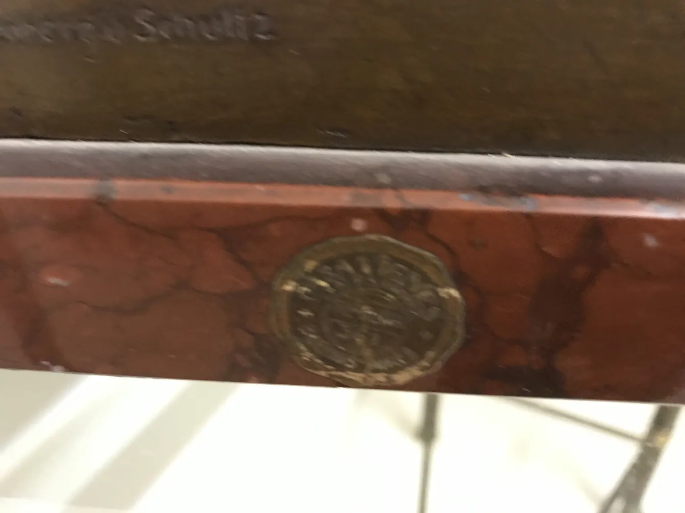 Alte Skulptur mit einem Siegel von Guss Wollenberg Schuttz. Sichtbare Details in einer eleganten Umgebung.