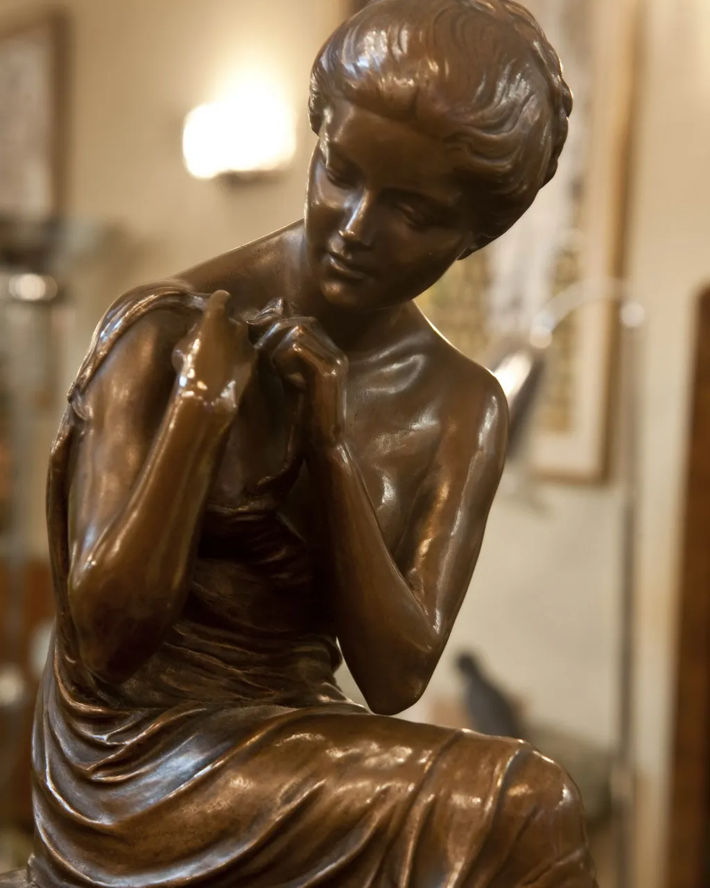 scultura antica di una donna in bronzo, con dettagli eleganti.