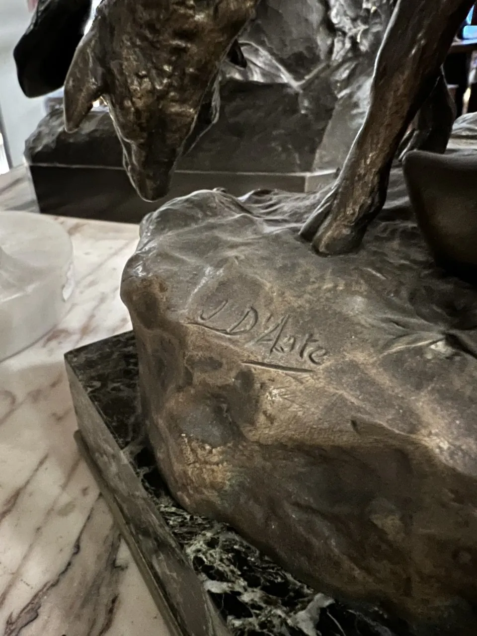 Antique sculpture featuring details like a signature, warm ambiance