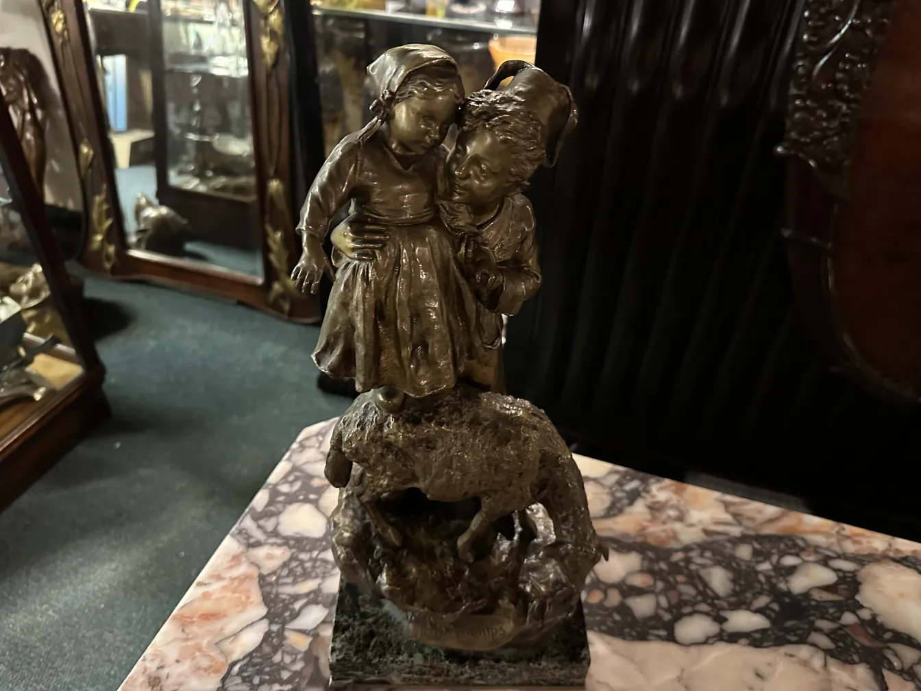 sculpture antique d'enfants s'embrassant dans un paysage