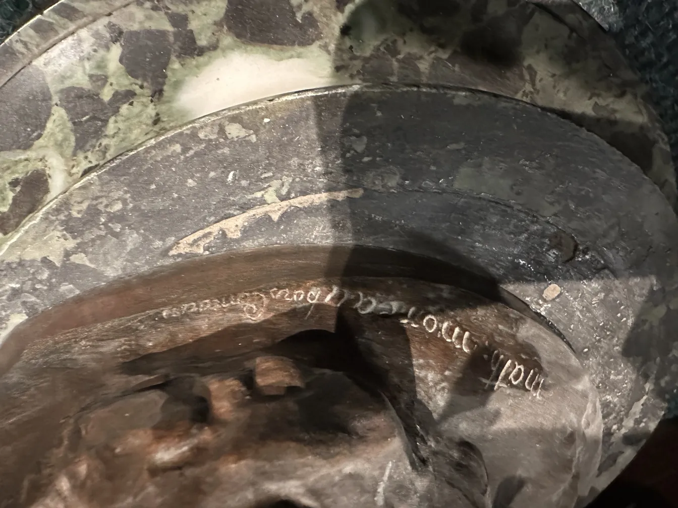 Detail of an ancient sculpture with visible inscription.