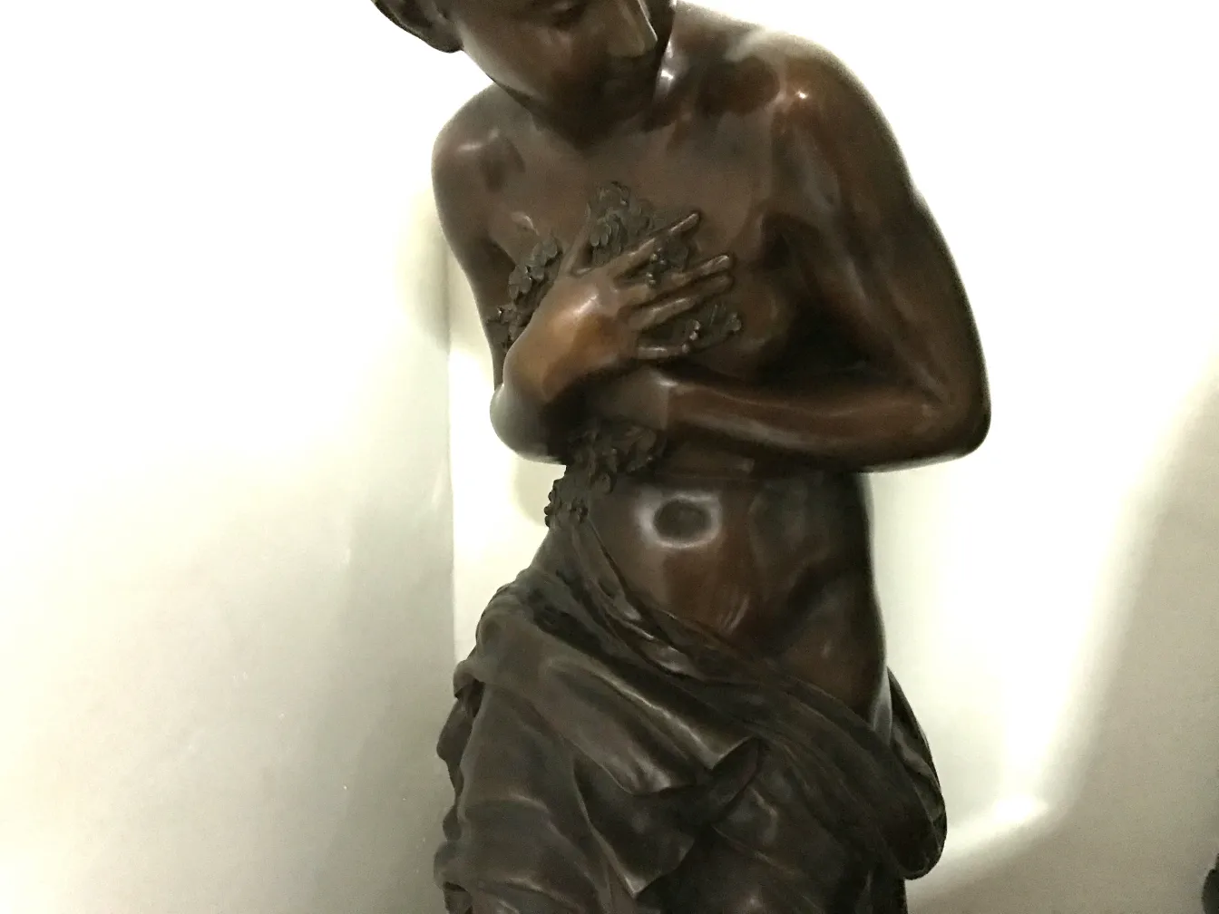 escultura antiga de figura feminina em tons escuros