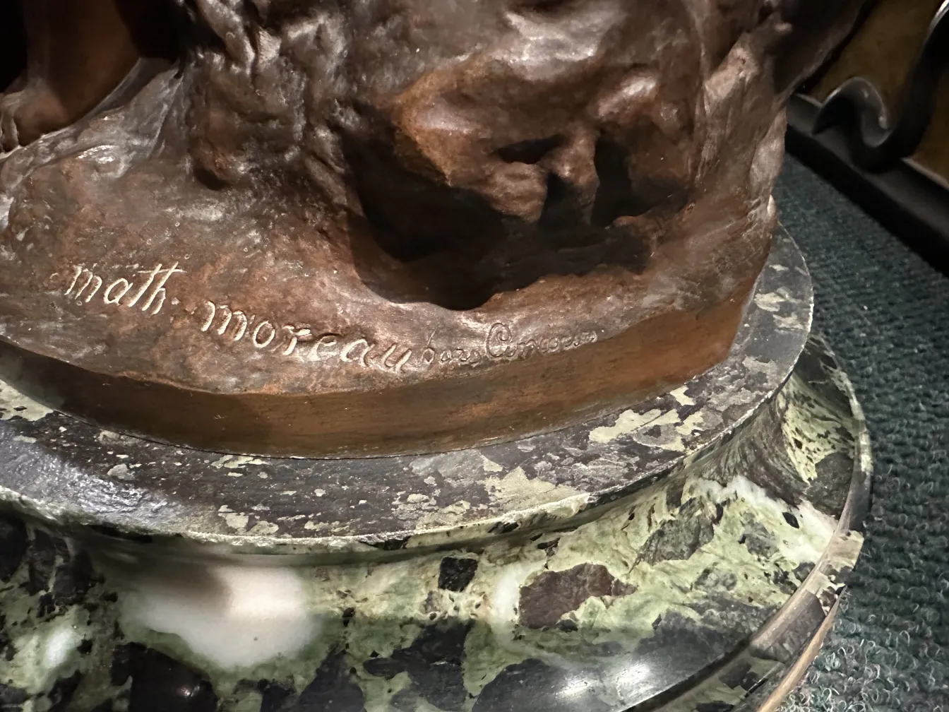 Detalhe de escultura antiga em bronze com base decorativa