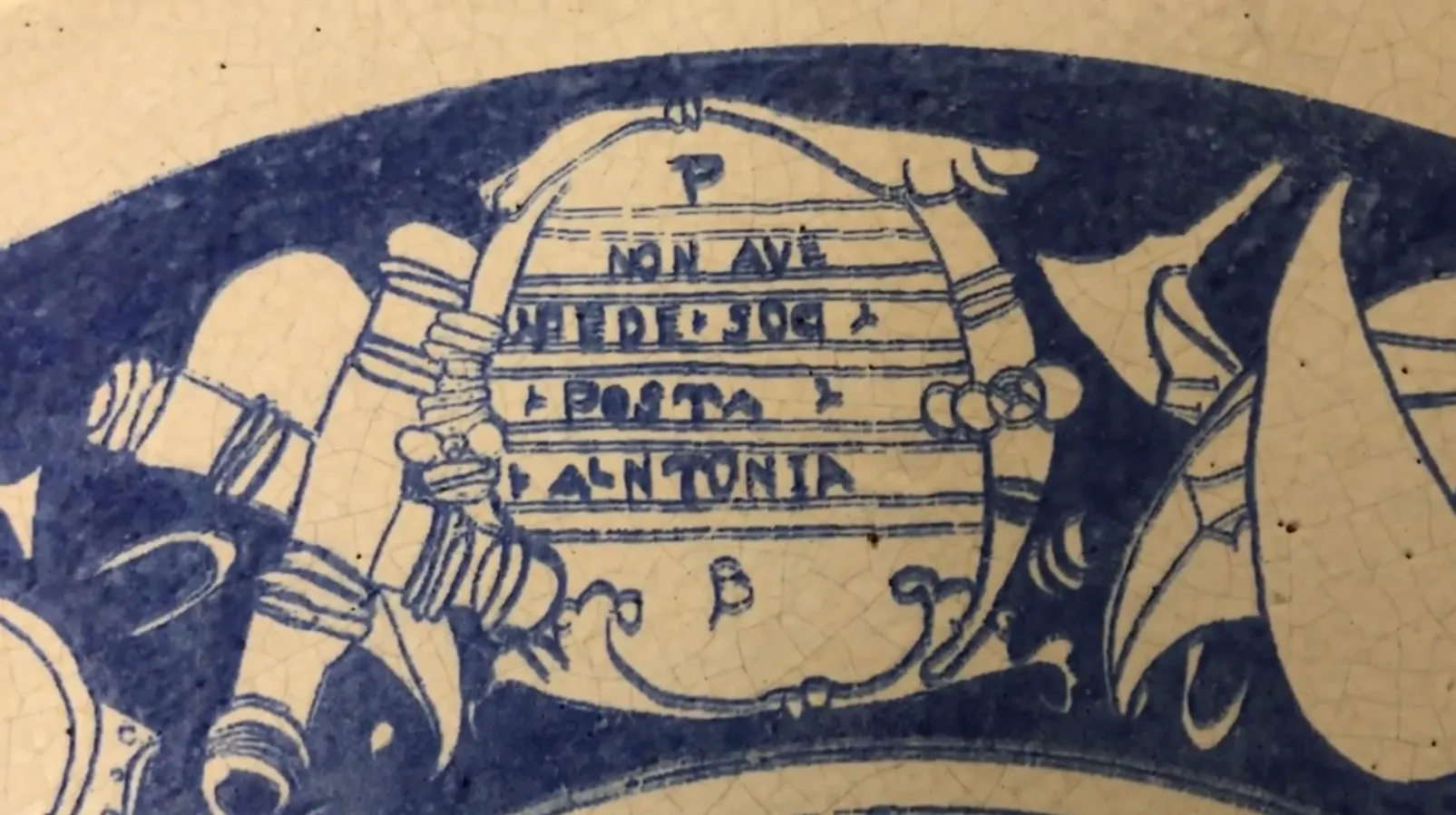 Ceramica antica blu con elementi decorativi distintivi.