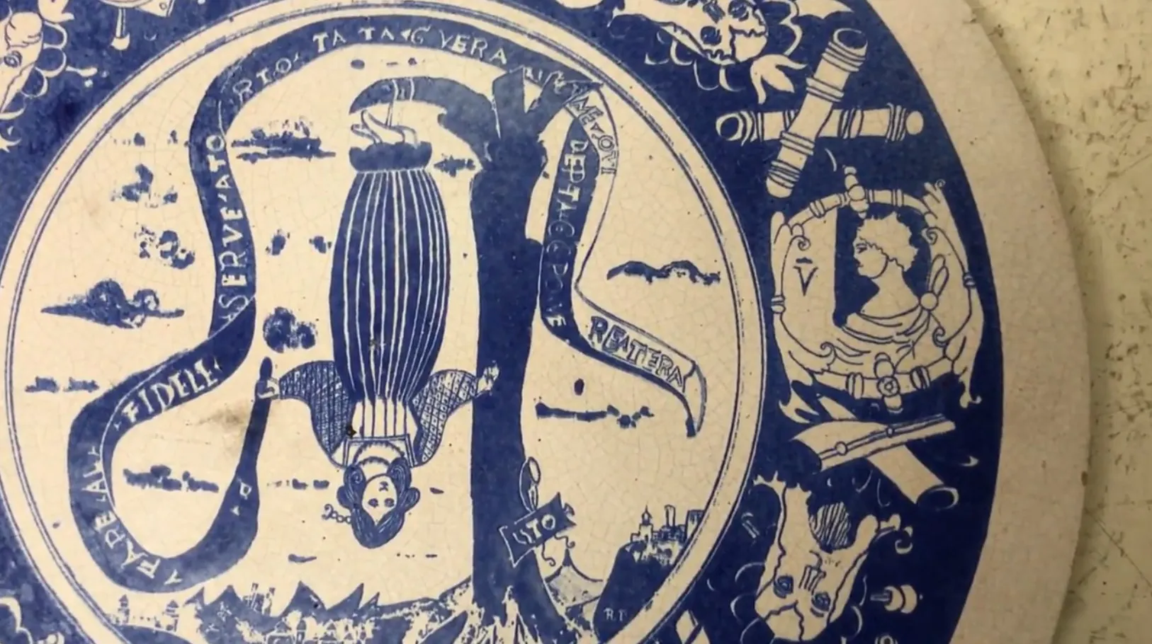 Plato antiguo de cerámica decorado con figuras y escenas.