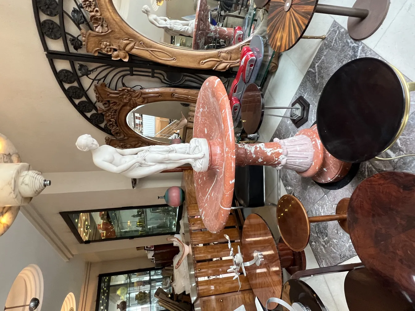 scultura bianca di figura umana su base in marmo in un ambiente elegante