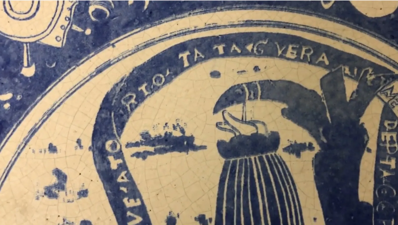 Antique ceramic with blue and white sea motifs, featuring visible cracks.