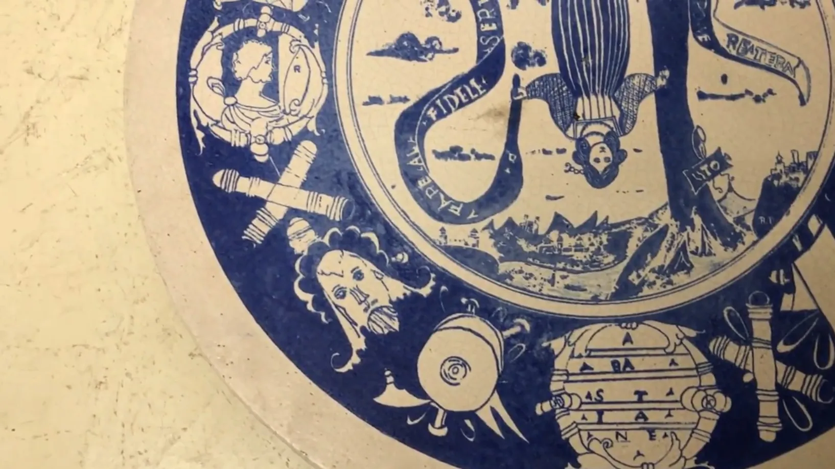 Antikes Keramikteller mit detailliertem blauen Design, das Figuren und Landschaften zeigt.